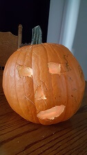 Curved Pumpkin. Two eyes a nose and a mouth with a candle inside
